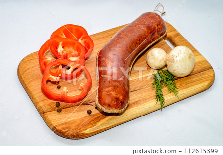 Tasty sausages and vegetables isolated over solid background Tasty sausages and vegetables isolated over solid background 112615399