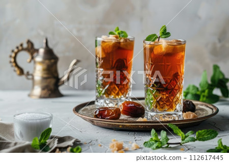 Moroccan tea in traditional glasses with mint, dates and sugar Moroccan tea in traditional glasses with mint, dates and sugar 112617445