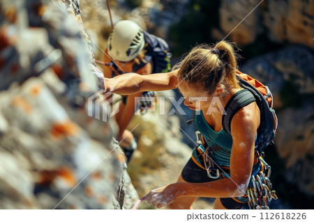 Women climb a rock while trekking outdoors. Generative AI 112618226