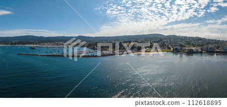 Beautiful aerial view of the Monterey town in California with many yachts docked by the pier. Beautiful aerial view of the Monterey town in California with many yachts docked by the pier. 112618895
