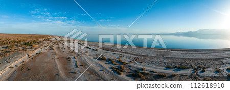 Aerial view over Salton sea in California. Huge lake in the middle of a desert at sunset. Aerial view over Salton sea in California. Huge lake in the middle of a desert at sunset. 112618910