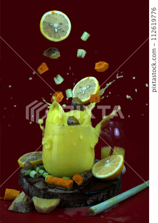 Glass filled with herbal drink of ginger, turmeric, lemon grass and lemon. 112619776