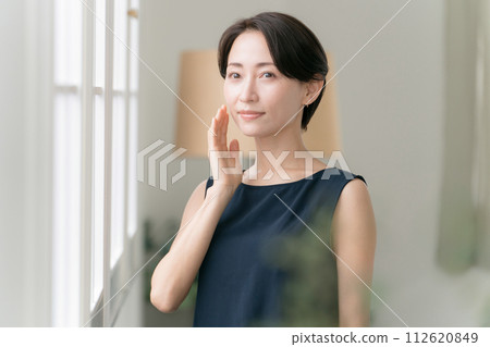 A woman in her 30s feels the moisture in her skin A woman in her 30s feels the moisture in her skin 112620849