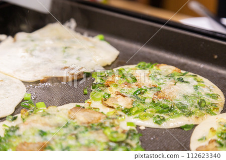 Grilled green onions made on a hot plate 112623340