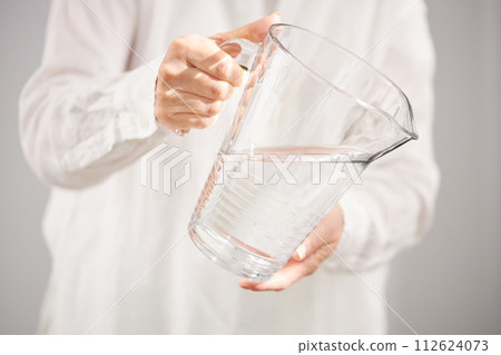 Hand of middle-aged woman pouring water 112624073
