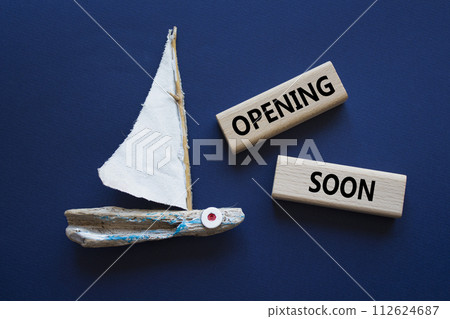 Opening soon symbol. Concept word Opening soon on wooden blocks. Beautiful deep blue background with boat. Business and Opening soon concept. Copy space 112624687