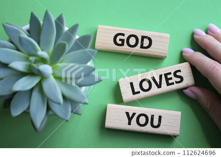 God loves you symbol. Wooden blocks with words God loves you. Beautiful green background with succulent plant. Prayer hand. Religion and God loves you concept. Copy space. God loves you symbol. Wooden blocks with words God loves you. Beautiful green background with succulent plant. Prayer hand. Religion and God loves you concept. Copy space. 112624696