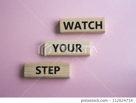 Watch your Step symbol. Concept words Watch your Step on wooden blocks. Beautiful pink background. Business and Watch your Step concept. Copy space. 112624714