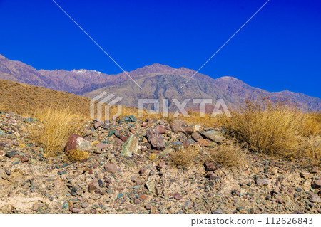 rocks and dry grass tufts in autumn mountains scene at sunny day rocks and dry grass tufts in autumn mountains scene at sunny day 112626843
