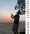 Celebrate by popping champagne on the beach at sunset 112627149