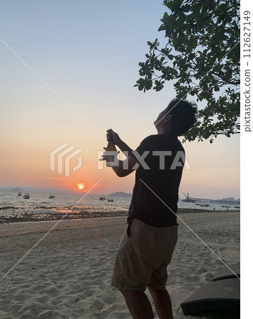 日落時在海灘上開香檳慶祝 日落時在海灘上開香檳慶祝 112627149