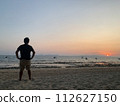 man watching sunset on the beach 112627150