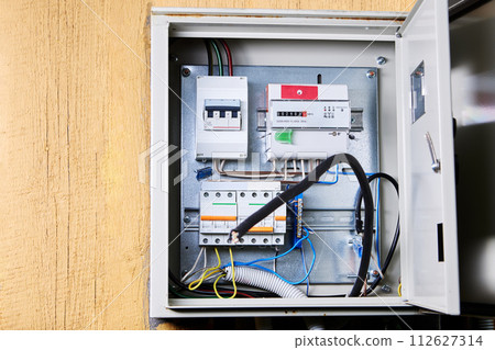 Open Electrical Panel Featuring Circuit Breakers and Wiring in Maintenance Room. 112627314