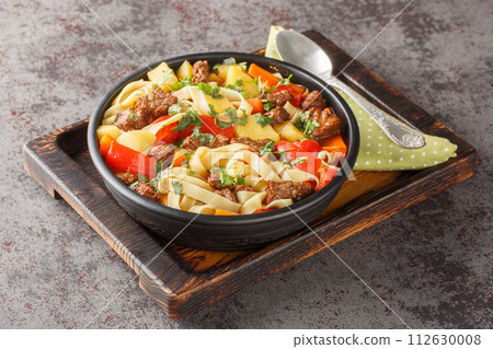 Lagman or Laghman thick Warming Beef Soup with homemade noodles and vegetables closeup on the plate. Horizontal Lagman or Laghman thick Warming Beef Soup with homemade noodles and vegetables closeup on the plate. Horizontal 112630008