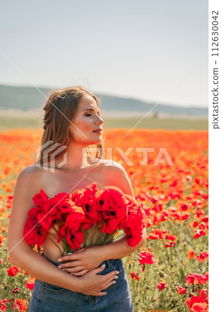 Woman poppies field. portrait happy woman with long hair in a poppy field and enjoying the beauty of nature in a warm summer day. 112630042