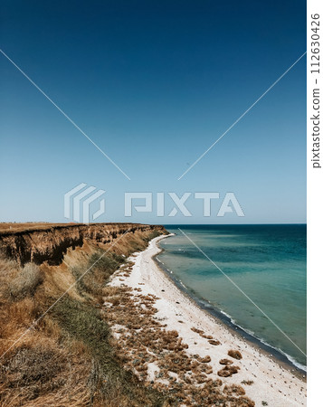 cliff sea blue aquamarine waves line sunny beach. Soft wave of ocean foam. 112630426