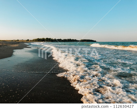 Sea blue aquamarine waves line sunny sand beach. Soft wave of ocean foam. Sea blue aquamarine waves line sunny sand beach. Soft wave of ocean foam. 112630427