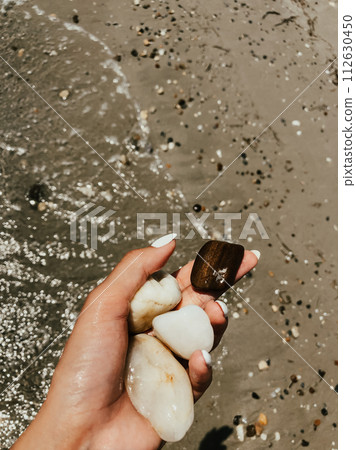 woman hand holding stones. Multicolored seashells Black Sea Romania. 112630450