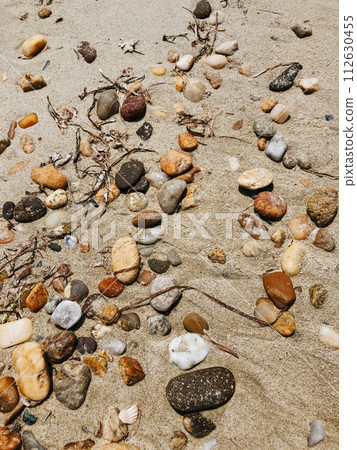 Sea stones on sandy wet beach. Summer background texture wallpaper. Sea stones on sandy wet beach. Summer background texture wallpaper. 112630455