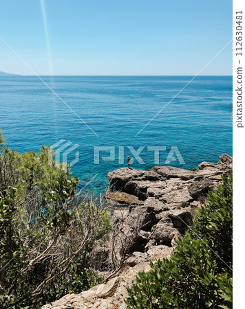 Old man hobby fishing angling standing on big rock stone. senior pensioner catches fish spinning Old man hobby fishing angling standing on big rock stone. senior pensioner catches fish spinning 112630481