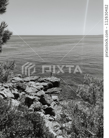 Old man hobby fishing angling standing on big rock stone. senior pensioner catches fish spinning Old man hobby fishing angling standing on big rock stone. senior pensioner catches fish spinning 112630482