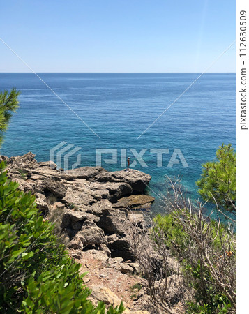 Old man hobby fishing angling standing on big rock stone. senior pensioner catches fish spinning Old man hobby fishing angling standing on big rock stone. senior pensioner catches fish spinning 112630509