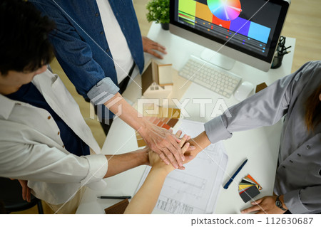 High angle view of architects or interior designers stacking hands over table 112630687