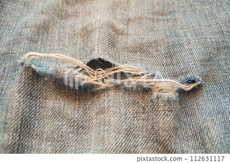 Close-up of ripped jeans with pile, wear and tear of clothes 112631117