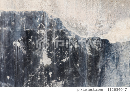old concrete wall with black paint leftovers covered with whitewash stains, full-frame background and texture old concrete wall with black paint leftovers covered with whitewash stains, full-frame background and texture 112634047