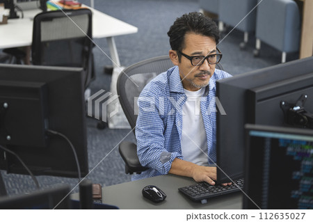 Engineer in his 50s working on a PC 112635027