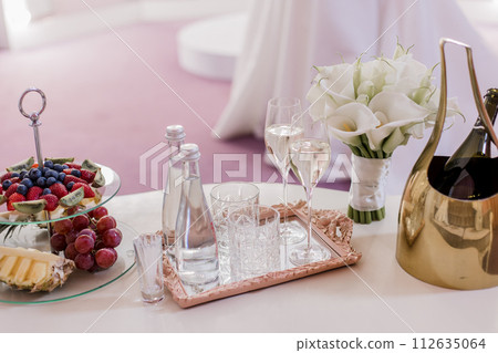 Elegant champagne flutes arranged on mirrored tray Elegant champagne flutes arranged on mirrored tray 112635064