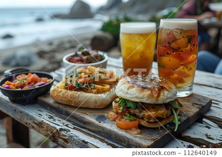 Illustration of delicious looking food beautifully arranged on a beach by the sea. Can be used to attract tourists, promote seaside restaurants, food products, catering services or travel packages Illustration of delicious looking food beautifully arranged on a beach by the sea. Can be used to attract tourists, promote seaside restaurants, food products, catering services or travel packages 112640149