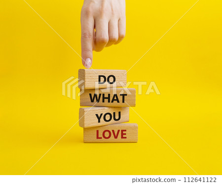 Do what you Love symbol. Concept words Do what you Love on wooden blocks. Beautiful yellow background. Businessman hand. Business and Do what you Love concept. Copy space Do what you Love symbol. Concept words Do what you Love on wooden blocks. Beautiful yellow background. Businessman hand. Business and Do what you Love concept. Copy space 112641122