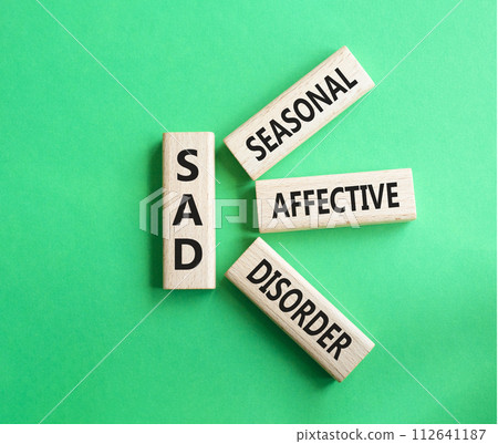 Sad - Seasonal Affective Disorder symbol. Wooden blocks with words Sad. Beautiful green background. Business and Sad concept. Copy space. 112641187