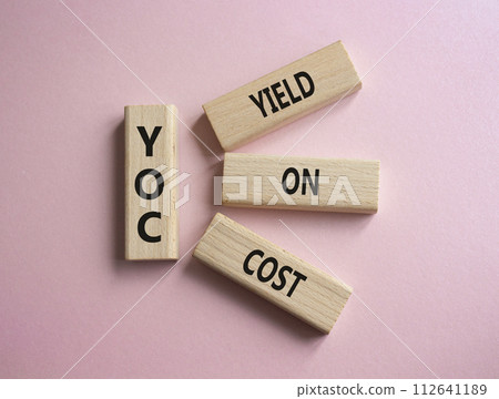 YOC - Yield on Cost. Wooden cubes with word YOC. Beautiful pink background. Business and YOC concept. Copy space. 112641189
