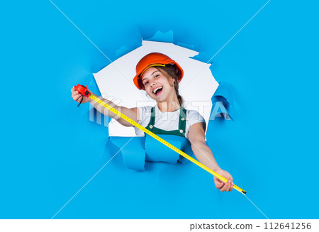 cheerful child laborer using building uniform and tape measure, measurement 112641256