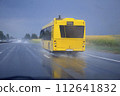 Yellow urban bus on its way on a wet road in the rain 112641832