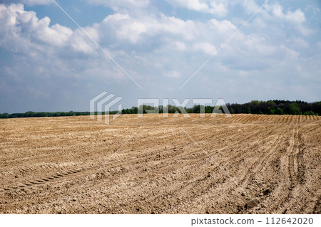 Ploughed agricultural land ready for sowing, sky above. Ploughed agricultural land ready for sowing, sky above. 112642020