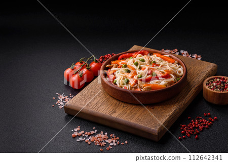 Delicious rice noodles or udon with chicken, carrots, pepper, salt, spices and herbs Delicious rice noodles or udon with chicken, carrots, pepper, salt, spices and herbs 112642341