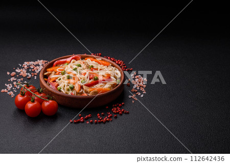 Delicious rice noodles or udon with chicken, carrots, pepper, salt, spices and herbs 112642436