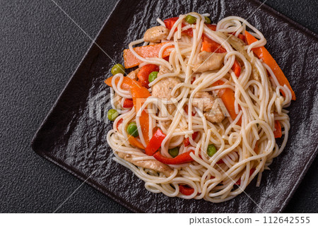 Delicious rice noodles or udon with chicken, carrots, pepper, salt, spices and herbs Delicious rice noodles or udon with chicken, carrots, pepper, salt, spices and herbs 112642555