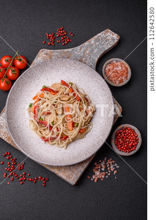 Delicious rice noodles or udon with chicken, carrots, pepper, salt, spices and herbs Delicious rice noodles or udon with chicken, carrots, pepper, salt, spices and herbs 112642580