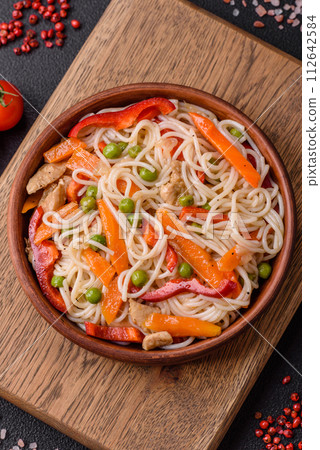 Delicious rice noodles or udon with chicken, carrots, pepper, salt, spices and herbs 112642584