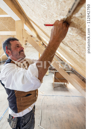 Construction woodworker measuring on site 112642760