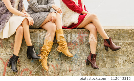 Three women presenting shoes outdoor Three women presenting shoes outdoor 112643315