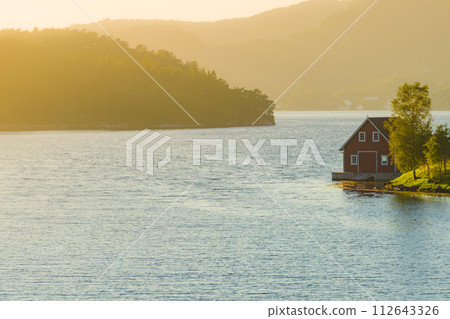 Wooden cabin on fjord shore, Norway Wooden cabin on fjord shore, Norway 112643326