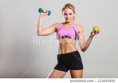 Diet fit body. Girl holds dumbbells and apple fruit 112643856
