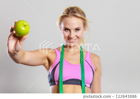 woman fit girl with measure tape and apple fruit woman fit girl with measure tape and apple fruit 112643886