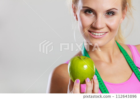 woman fit girl with measure tape and apple fruit woman fit girl with measure tape and apple fruit 112643896