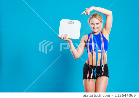 Fit woman with measure tape with weight scale Fit woman with measure tape with weight scale 112644069